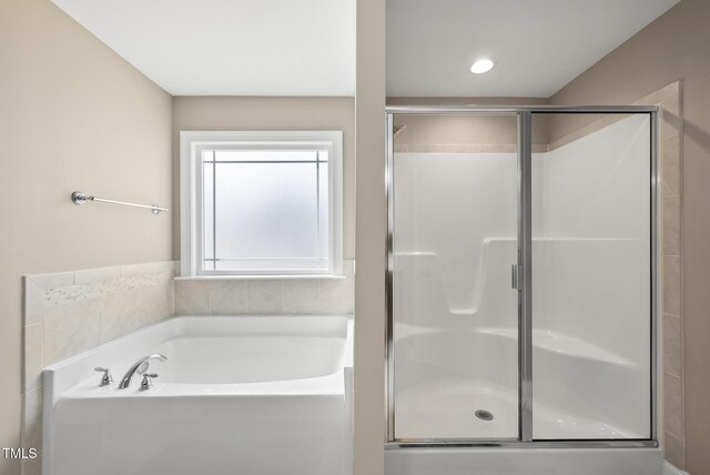 full bathroom featuring a shower stall and a bath