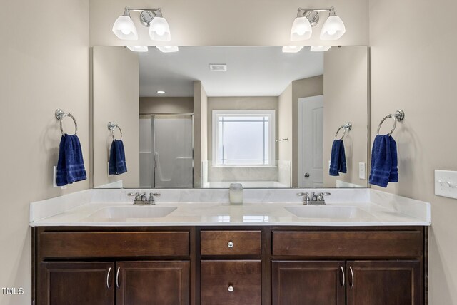 full bath with double vanity, a sink, and a stall shower