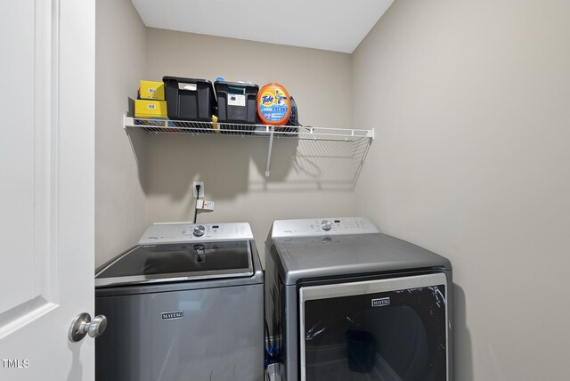 washroom with washing machine and clothes dryer and laundry area