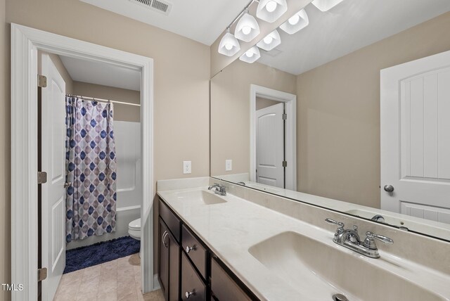 bathroom featuring double vanity, toilet, visible vents, and a sink