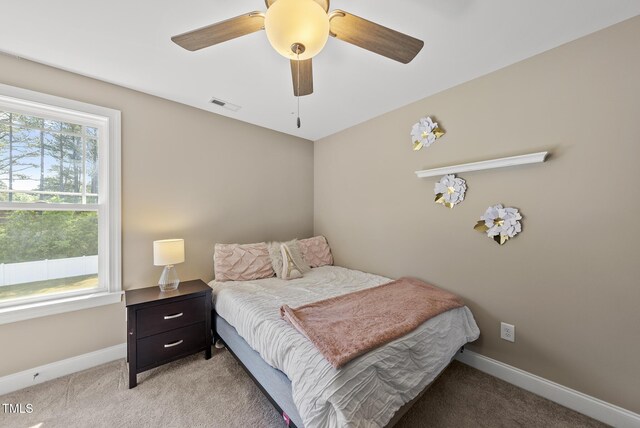 bedroom with visible vents, a ceiling fan, baseboards, and light carpet