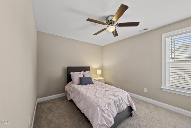 bedroom with a ceiling fan, baseboards, visible vents, and carpet