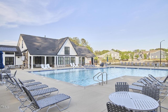 community pool featuring a patio area and fence