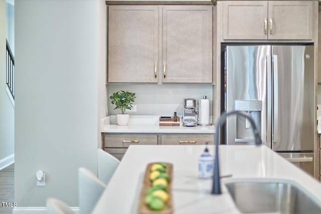 kitchen with stainless steel fridge, light countertops, and baseboards