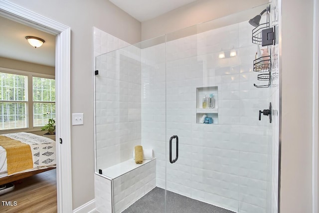 bathroom featuring baseboards, a stall shower, and ensuite bath