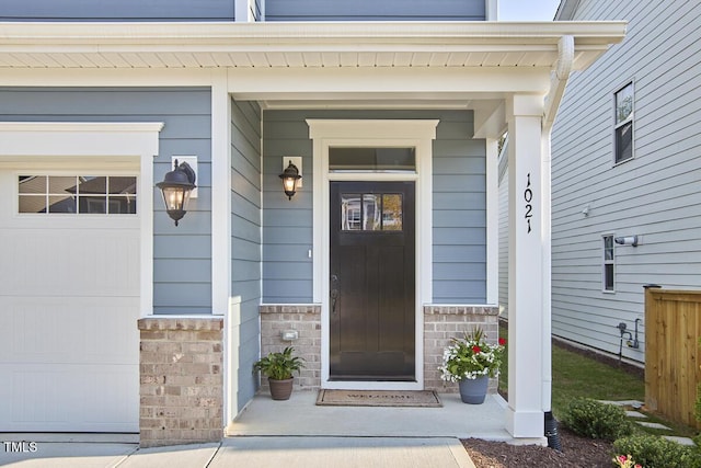 entrance to property with a porch and stone siding