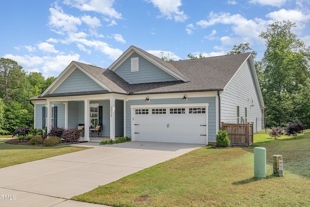 traditional home with covered porch, an attached garage, concrete driveway, and a shingled roof