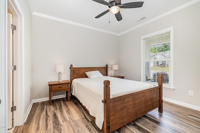 bedroom featuring ornamental molding, baseboards, wood finished floors, and a ceiling fan