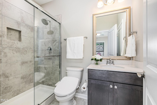 full bath featuring a stall shower, toilet, vanity, and baseboards