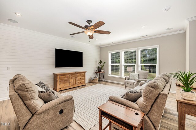 living room featuring light wood-style flooring, a ceiling fan, baseboards, crown molding, and recessed lighting