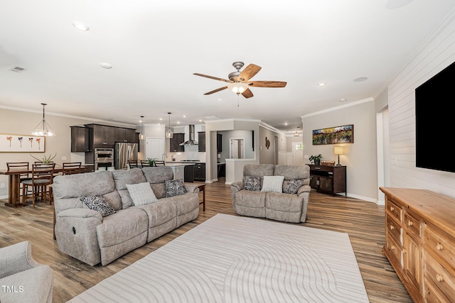 living room with ornamental molding, ceiling fan, wood finished floors, baseboards, and recessed lighting
