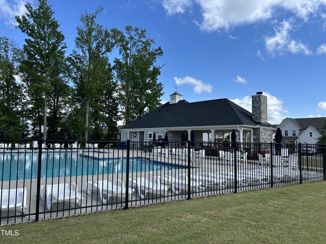 community pool with fence and a patio