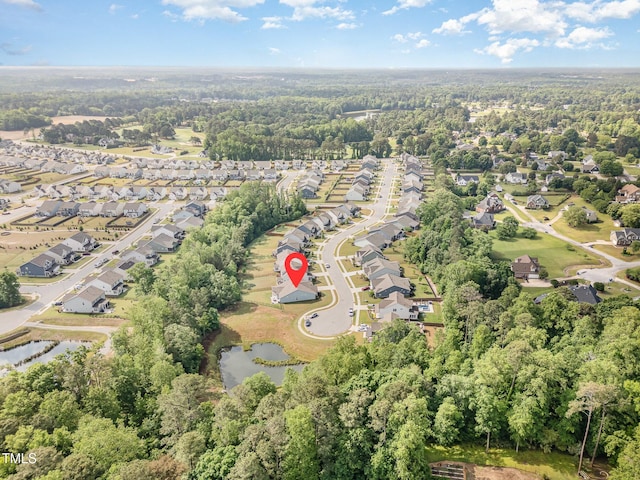 view of property location with nearby suburban area, a large body of water, and a forest