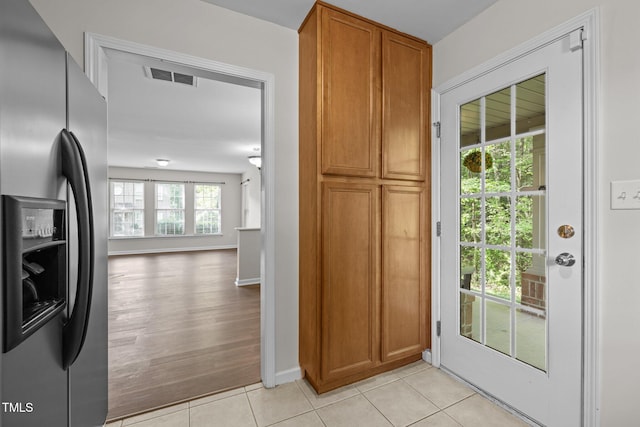 interior space with light tile patterned flooring, baseboards, and visible vents