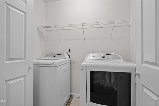 clothes washing area featuring laundry area and washer and clothes dryer