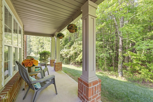 view of patio featuring a view of trees and covered porch