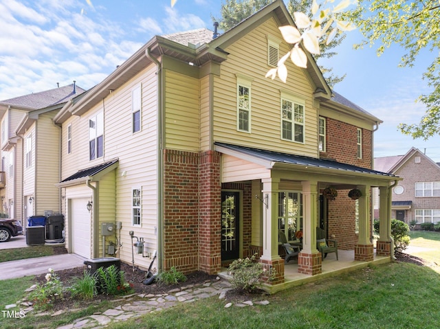 view of front of property featuring covered porch, driveway, a front yard, brick siding, and an attached garage
