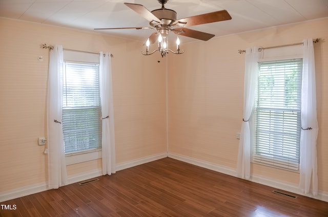 spare room featuring a ceiling fan, wood finished floors, baseboards, and plenty of natural light