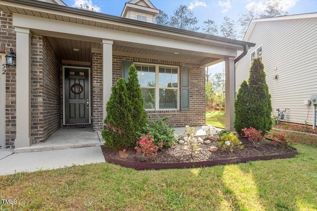 52 Brunello Ct, Clayton, NC 27527 - doorway to property with a lawn, covered porch, and brick siding
