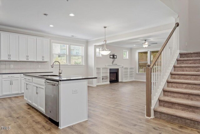 52 Brunello Ct, Clayton, NC 27527 - kitchen with dark countertops, a sink, dishwasher, open floor plan, and ornamental molding