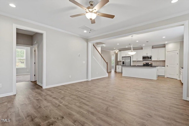 52 Brunello Ct, Clayton, NC 27527 - unfurnished living room featuring crown molding, stairs, baseboards, a ceiling fan, and light wood finished floors