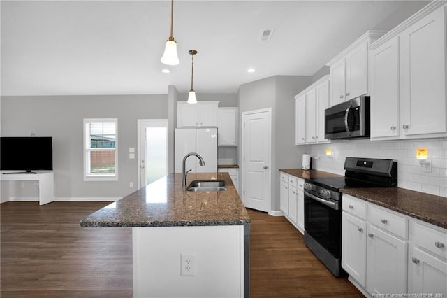 kitchen with a sink, dark wood finished floors, stainless steel appliances, white cabinetry, and tasteful backsplash
