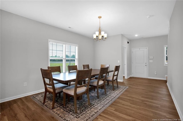 dining room featuring baseboards, wood finished floors, and a chandelier