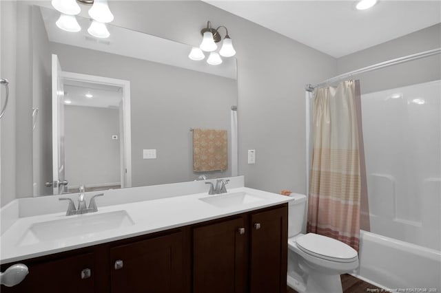full bathroom with a sink, toilet, double vanity, and visible vents