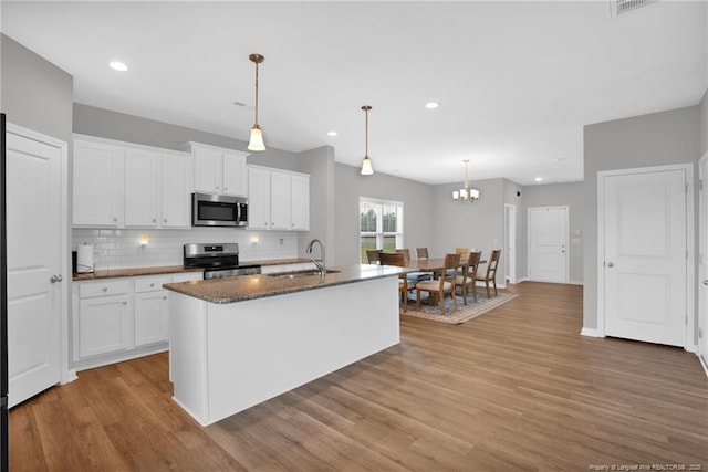 566 Carolina Church Rd, Saint Pauls, NC 28384 - kitchen featuring appliances with stainless steel finishes, a sink, light wood-style floors, backsplash, and white cabinets