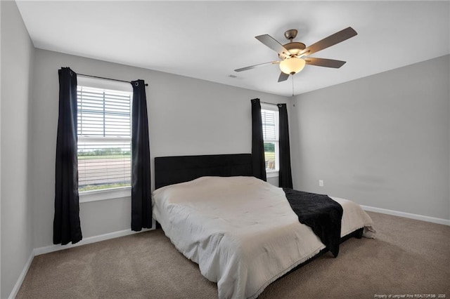 566 Carolina Church Rd, Saint Pauls, NC 28384 - carpeted bedroom featuring multiple windows, baseboards, and ceiling fan
