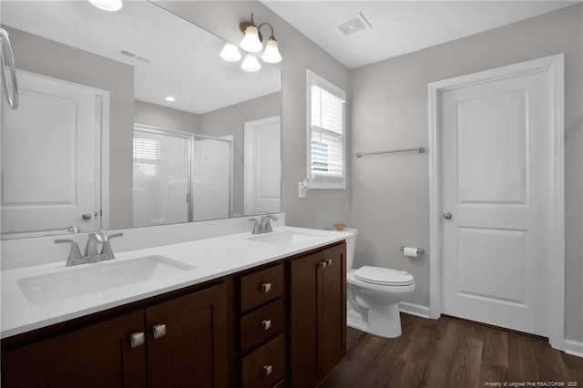 566 Carolina Church Rd, Saint Pauls, NC 28384 - bathroom with wood finished floors, a stall shower, double vanity, toilet, and baseboards