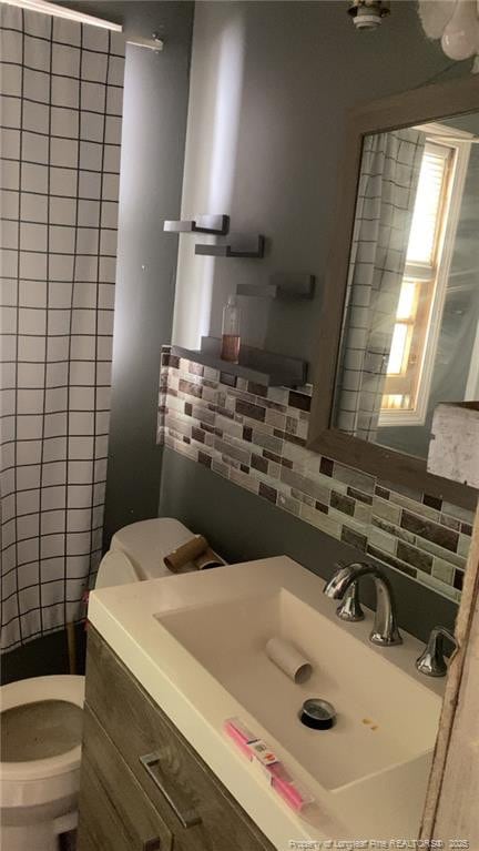 bathroom with vanity, tasteful backsplash, and toilet