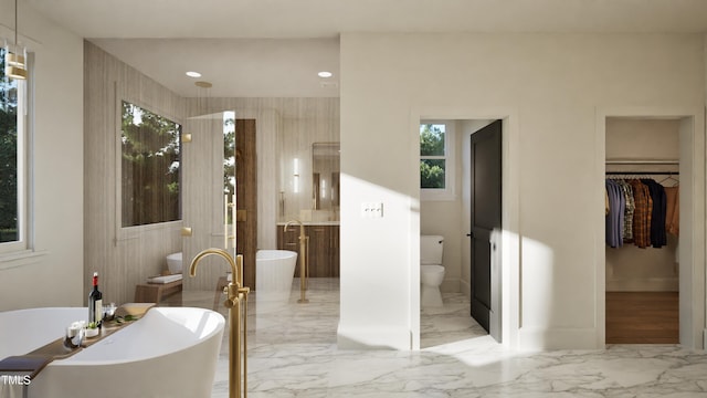 909 Oberlin Rd, Raleigh, NC 27605 - full bathroom featuring toilet, marble finish floor, a spacious closet, baseboards, and a freestanding tub