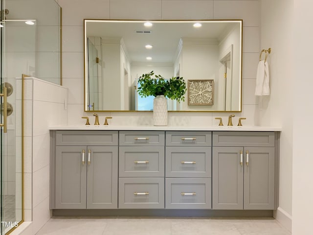 full bath featuring a sink, a stall shower, double vanity, and visible vents