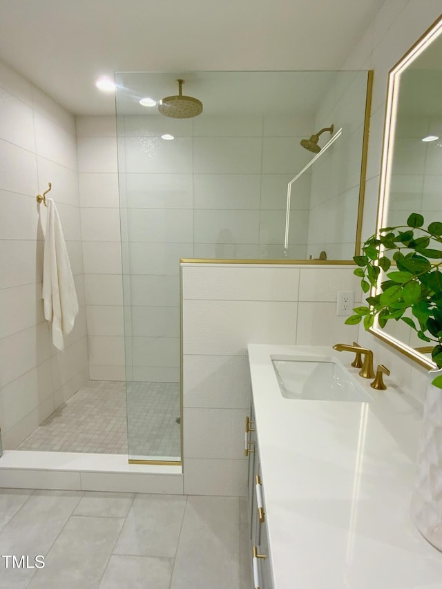 full bath featuring a walk in shower, tile patterned floors, tile walls, and vanity