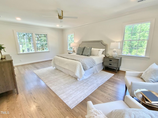 bedroom with crown molding, baseboards, visible vents, and light wood-type flooring