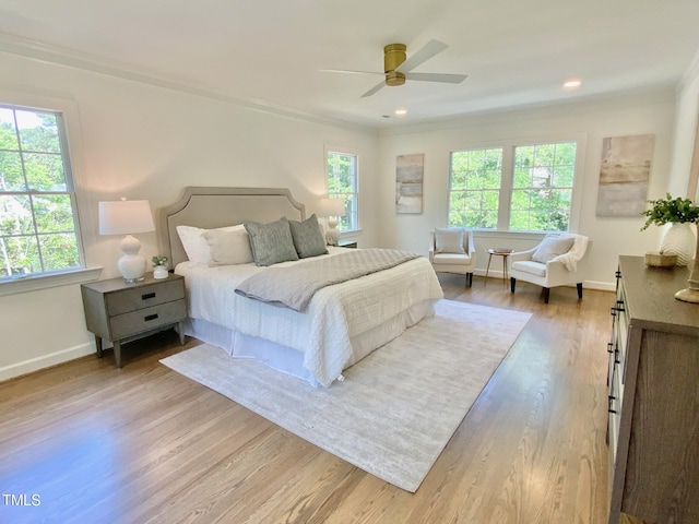 bedroom featuring crown molding, baseboards, ceiling fan, and light wood finished floors