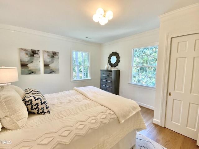 bedroom featuring crown molding, baseboards, and wood finished floors