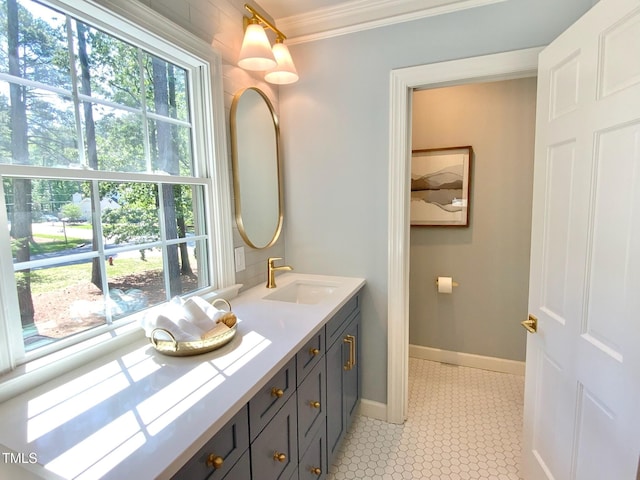 bathroom featuring crown molding, baseboards, and vanity