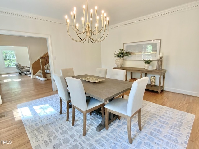 dining space with an inviting chandelier, light wood-style floors, baseboards, visible vents, and stairway