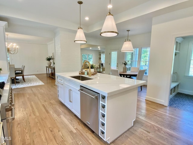 kitchen featuring stainless steel dishwasher, baseboards, a sink, and light wood-style floors