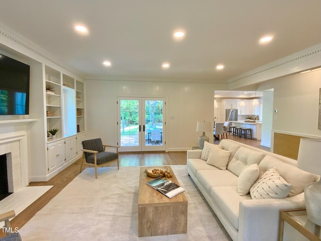 living room with french doors, a fireplace, wood finished floors, ornamental molding, and recessed lighting