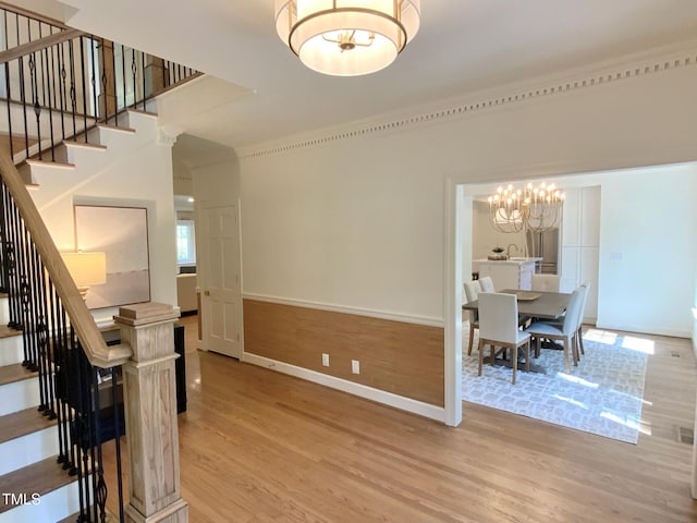 interior space featuring baseboards, a chandelier, and wood finished floors