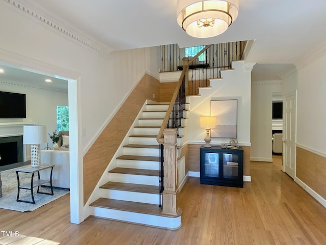 stairway with baseboards, a fireplace, and wood finished floors