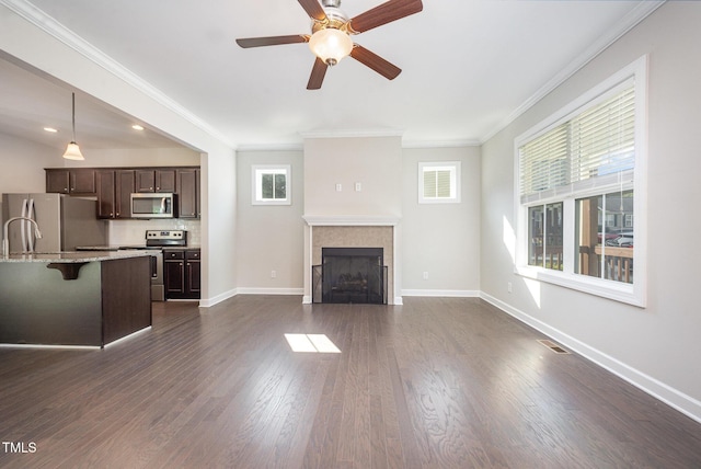 107 Cottage Ct, Youngsville, NC 27596 - unfurnished living room with a ceiling fan, a fireplace, ornamental molding, and dark wood-style floors