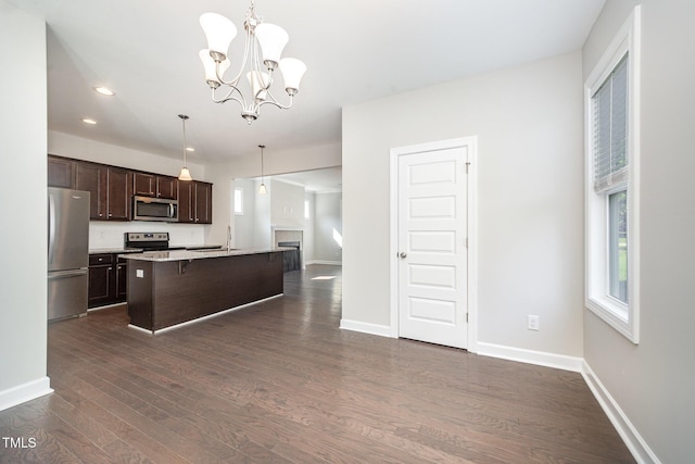 107 Cottage Ct, Youngsville, NC 27596 - kitchen with stainless steel appliances, dark brown cabinets, a breakfast bar, dark wood-style flooring, and a chandelier