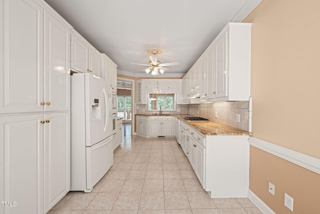 kitchen with ceiling fan, backsplash, a sink, white fridge with ice dispenser, and white cabinetry