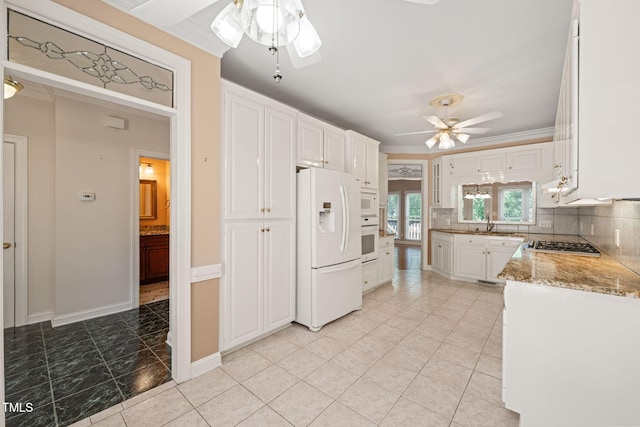 kitchen with ceiling fan, white appliances, white cabinetry, tasteful backsplash, and ornamental molding