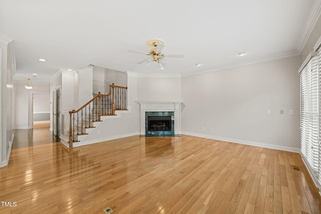 unfurnished living room with baseboards, a ceiling fan, light wood finished floors, and stairs