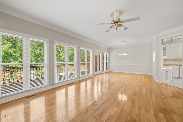 unfurnished living room featuring visible vents, crown molding, baseboards, light wood-type flooring, and ceiling fan with notable chandelier